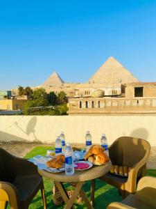 a table with a tray of bread and water bottles at Alma Pyramids View in Cairo