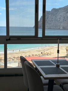 uma mesa com cadeiras e vista para a praia em Alecus em Calpe