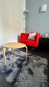 a living room with a table and a red chair at Chambre Privée Kozy - Stade de France in Saint-Denis