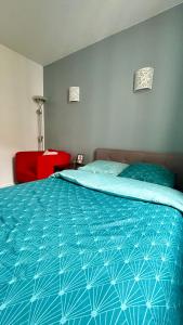 a bedroom with a bed with a blue comforter at Chambre Privée Kozy - Stade de France in Saint-Denis