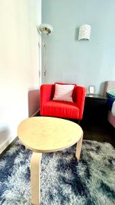 a living room with a red couch and a coffee table at Chambre Privée Kozy - Stade de France in Saint-Denis