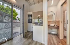 een keuken met witte kasten en een groot raam bij FORESTERIA GUESTHOUSE CA' DEI BACHITT in Lierna +37 foto's