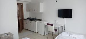 una pequeña cocina con fregadero y una mesa con una silla en Ritim Apart Hotel, en Turgutreis