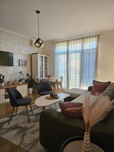 sala de estar con sofá verde y mesa en Apartments Becici, en Budva