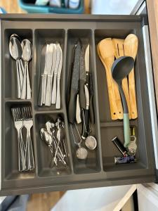 a black tray with utensils in a drawer at Pine cone cozy apartment in Rīga