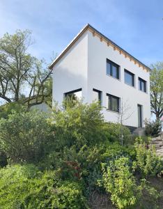 a white house on a hill with bushes at Tiny House Wettelsheim in Treuchtlingen
