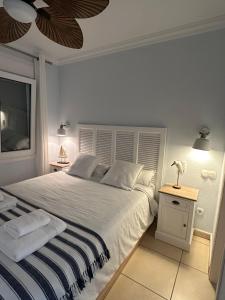 Un dormitorio blanco con una cama grande y una mesa. en Oliva Nova flat in front of MET, en Oliva