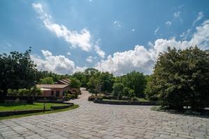 une allée pavée dans un parc avec un ciel bleu dans l'établissement Borgata Baldazza, à Linguaglossa