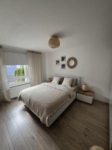 Habitación blanca con cama y ventana en Deep Blue - Apartament Hel, en Hel