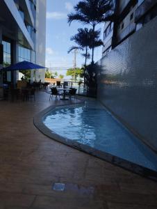uma piscina no meio de um edifício em PAJUCARA FRONT BEACH 2 em Maceió
