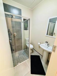 a bathroom with a shower and a toilet and a sink at The Place at Mall of Africa 2 in Midrand