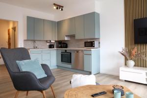 ein Wohnzimmer mit einem Stuhl und einem Tisch in der Unterkunft Seeblick25 - Apartments - Balkony - WIFI - Great View - New & Modern in Winterberg