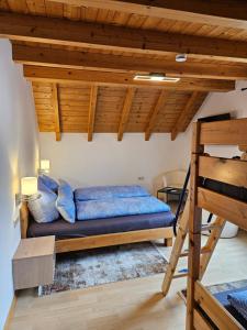 a bed in a room with a wooden ceiling at Gästehaus Rana in Rust