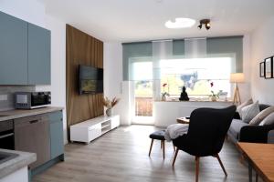 eine Küche und ein Wohnzimmer mit einem Sofa und einem Tisch in der Unterkunft Seeblick25 - Apartments - Balkony - WIFI - Great View - New & Modern in Winterberg