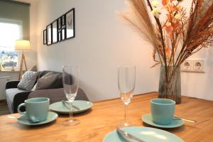溫特貝格的住宿－Seeblick25 - Apartments - Balkony - WIFI - Great View - New & Modern，一张桌子,上面放着两杯酒,花瓶上放着鲜花