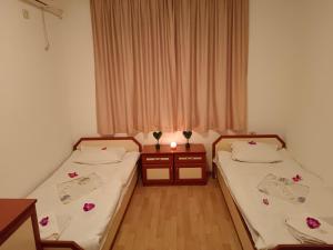 two beds in a small room with flowers on them at Стаи за гости Ники in Nesebar