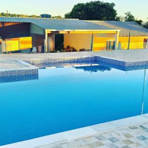 una casa con una piscina azul frente a ella en Pousada Chacara Princesa Isabel en São José da Barra
