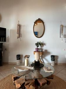 salon ze szklanym stołem i lustrem w obiekcie Avra Beach House w mieście Glífa