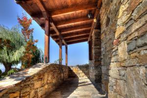 a stone wall with a wooden roof on a building at Petrina House in Angistron