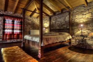 a bedroom with a bed in a stone wall at Petrina House in Ángistron