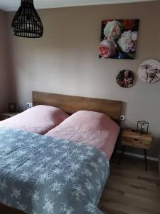 - une chambre avec 2 lits et une table avec une photo sur le mur dans l'établissement B&B weidse blik Ingelum, à Engelum