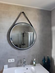 een badkamer met een spiegel boven een wastafel bij B&B weidse blik Ingelum in Engelum