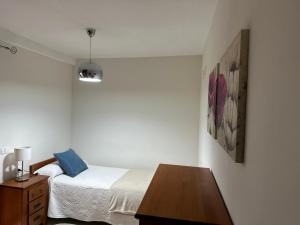 1 dormitorio con cama y mesa de madera en Vivienda Vacacional VillaVerde, en Valverde