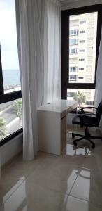 escritorio y silla en una habitación con ventanas en Casa Mina, en Las Palmas de Gran Canaria