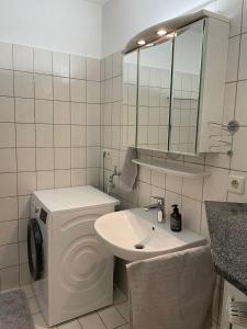 ein Badezimmer mit einem Waschbecken, einem WC und einem Spiegel in der Unterkunft Ferienwohnung Thedo in Bad Zwischenahn