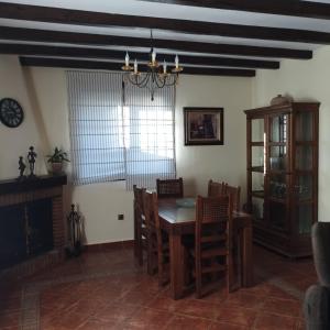 een eetkamer met een tafel en stoelen en een kroonluchter bij Casa Ayala in Ronda