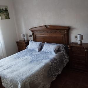 een slaapkamer met een bed met een houten hoofdeinde en kussens bij Casa Ayala in Ronda