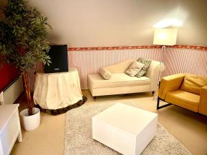 a living room with a couch and a tv at Villa Julian Mansarde in Aurich