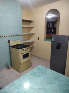a kitchen with a stove and a refrigerator at Casa Granada Jilotepec in Jilotepec