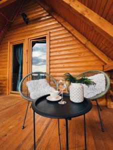 two chairs and a table in front of a cabin at CASA MIA in Kupres