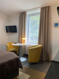a hotel room with a bed and a table and a window at S-VILLA Apartments im Schwarzwald in Schiltach