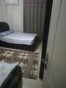 a room with two beds and a door with rugs at Lasirena mini egypt elsokhna in Ain Sokhna