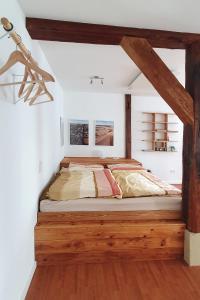 a bed in a room with white walls and wooden floors at Sinsheim Ferienwohnung in Sinsheim