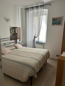a bedroom with a large bed and a window at Appartamento in tipico carugio ligure in Monterosso al Mare