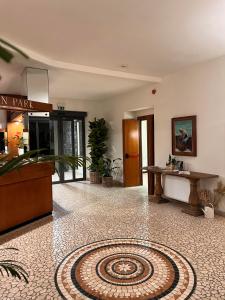 un vestíbulo con una mesa y una alfombra en el suelo en Hotel Eden Park, en Diano Marina
