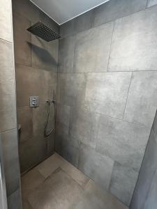 a shower with a glass door in a bathroom at Ferienwohnung - Haus mit Faßsauna - Nähe Fulda in Großenlüder +17 photos