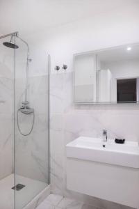 a white bathroom with a sink and a shower at T2 La Joliette, 13002 Marseille in Marseille