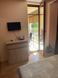 a bedroom with a bed and a tv on a wall at Частен апартамент Лагуна - Private Two-Bedroom Apartment Laguna in Primorsko
