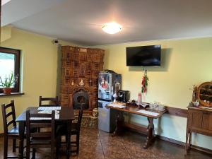 a living room with a table and a kitchen with a refrigerator at Casa Adelmar in Tulcea