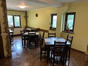 a dining room with tables and chairs and windows at Casa Adelmar in Tulcea