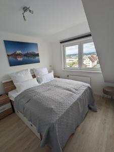 ein Schlafzimmer mit einem großen Bett und zwei Fenstern in der Unterkunft Hercules Horizon Apartment in Kassel