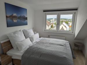 ein Schlafzimmer mit einem Bett und einem großen Fenster in der Unterkunft Hercules Horizon Apartment in Kassel