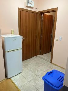 a kitchen with a white refrigerator and a blue trash can at Частен апартамент Лагуна - Private Two-Bedroom Apartment Laguna in Primorsko +6 photos