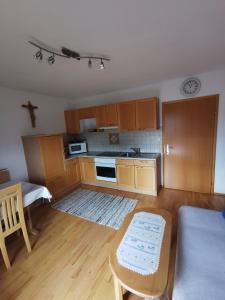 una pequeña cocina con armarios de madera y una mesa. en Haus Schrei, en Grundlsee