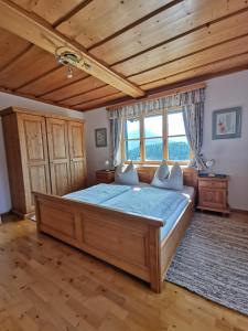 een slaapkamer met een groot bed in een kamer met houten plafonds bij Haus Schrei in Grundlsee