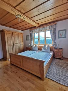 Un dormitorio con una cama grande en una habitación con techos de madera. en Haus Schrei, en Grundlsee